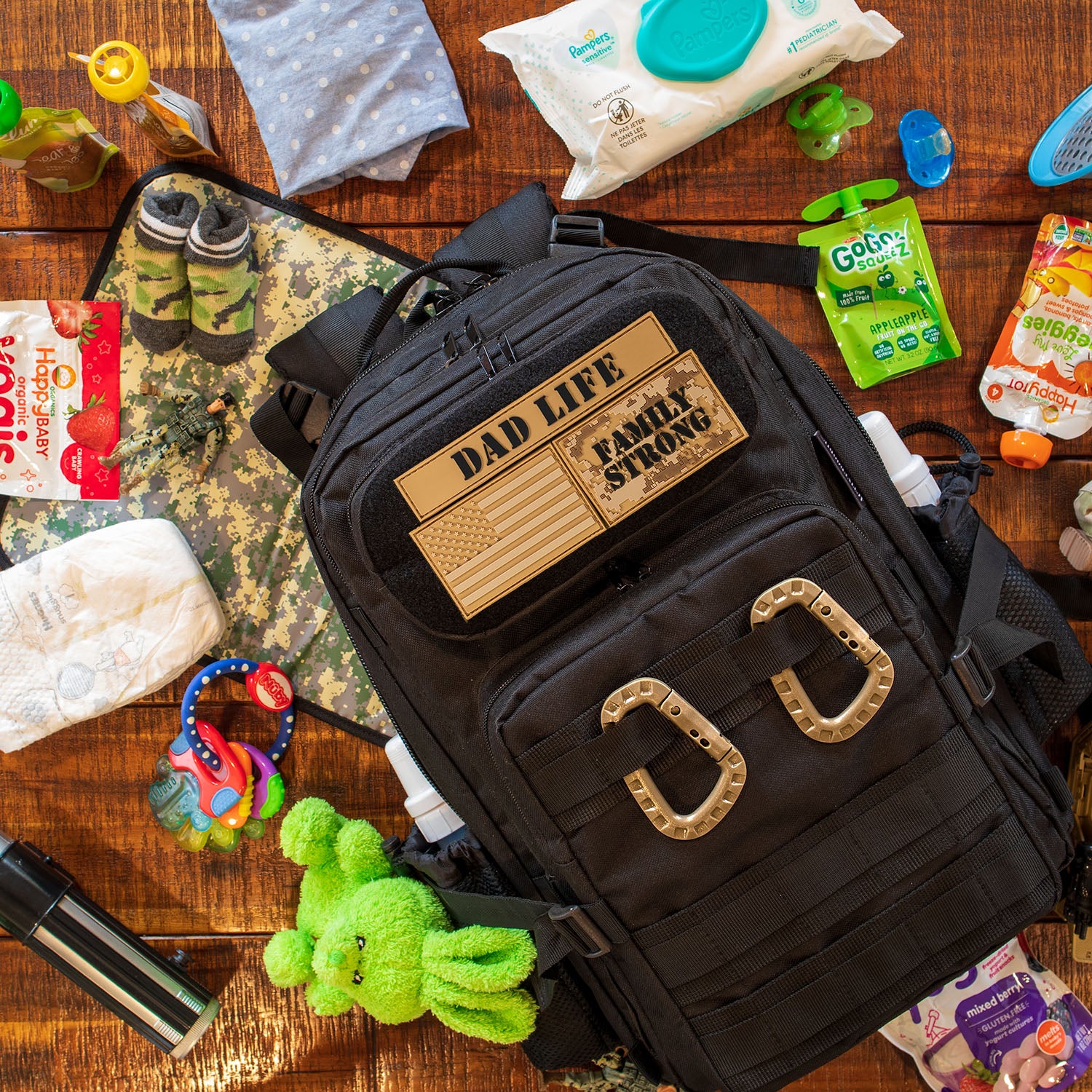 Dad Diaper Bag with dad life patches laying on table with baby gear