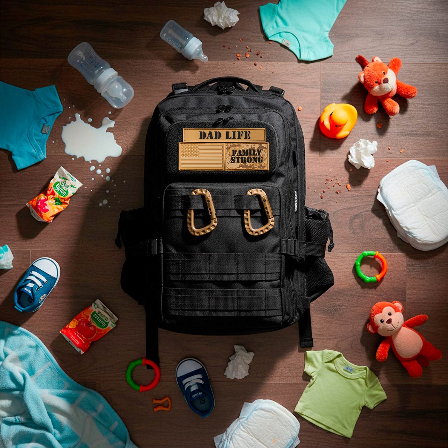 Black backpack labeled 'Dad Life' surrounded by baby items on a wooden surface