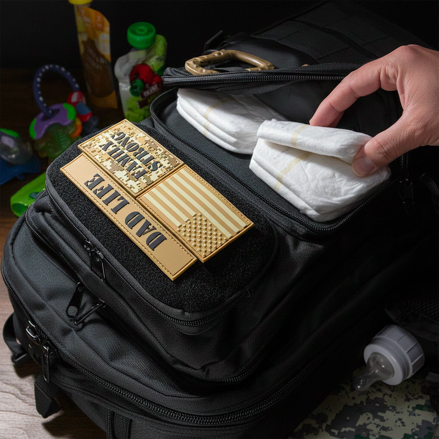 Black manly diaper bag backpack with dad life patches and a hand holding a white cloth. Active Doodie Gear - ADG42