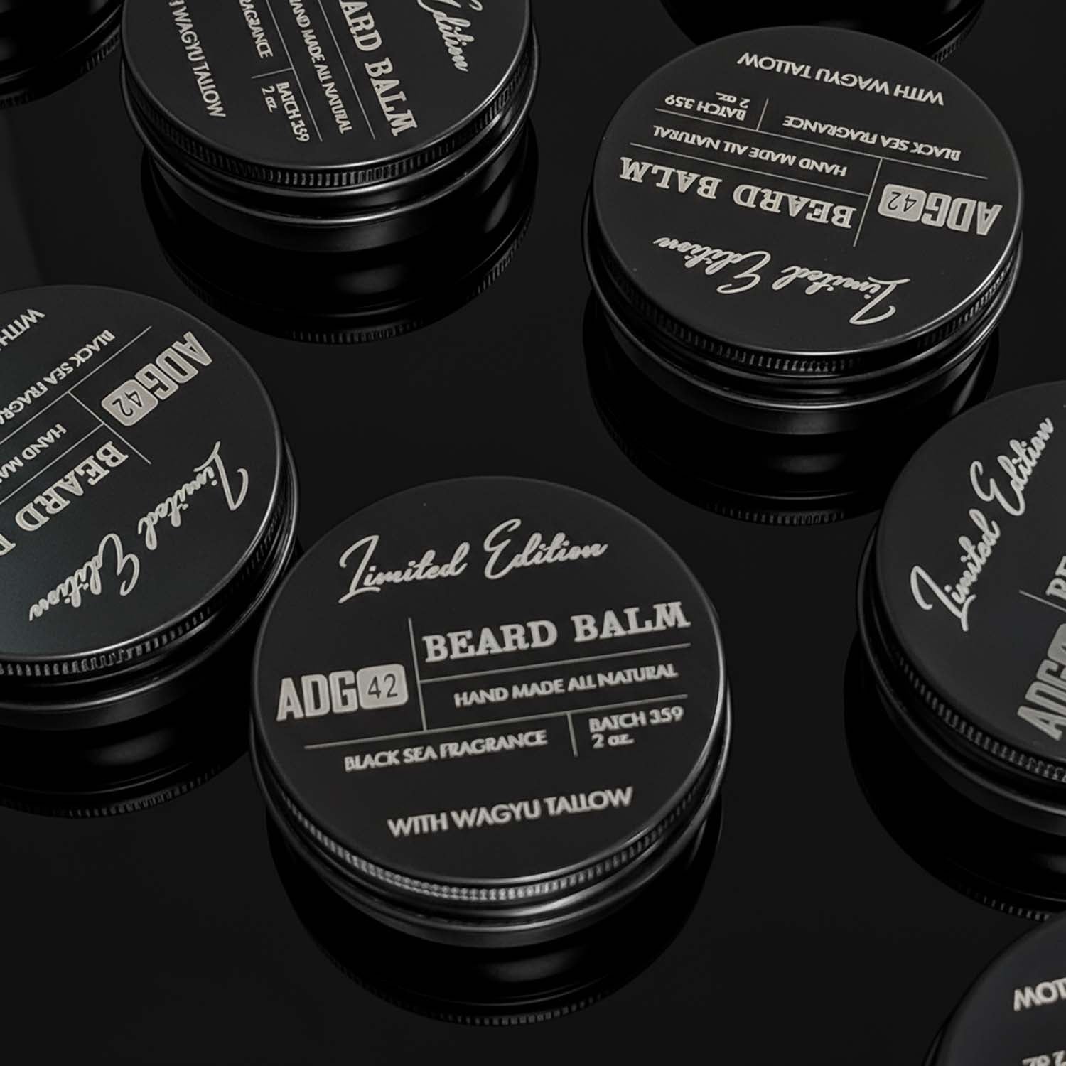 Multiple containers of ADG 42 Beard Balm on a black background