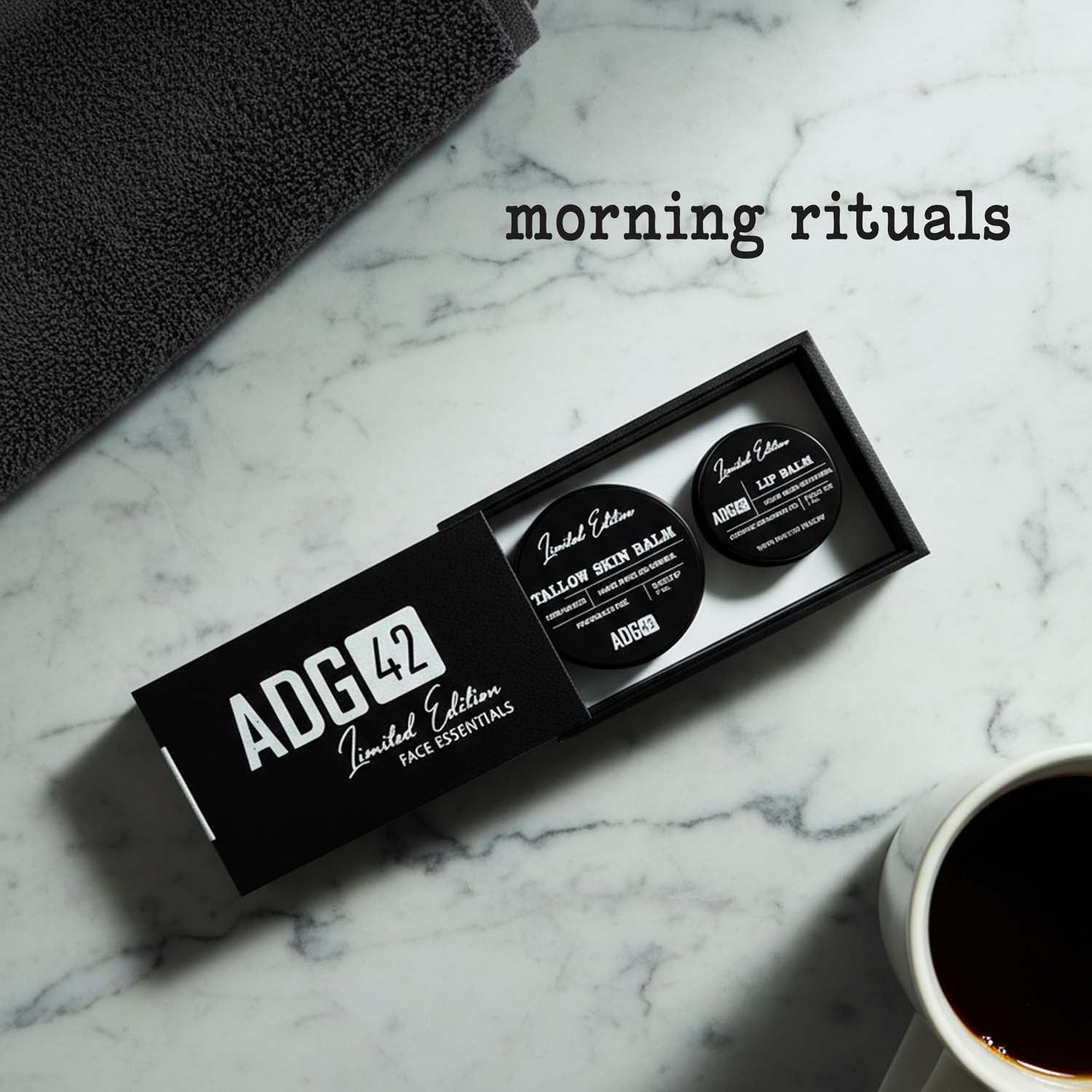 Two lip balms in a black box labeled 'ADG 42' on a marble surface with a towel and cup.