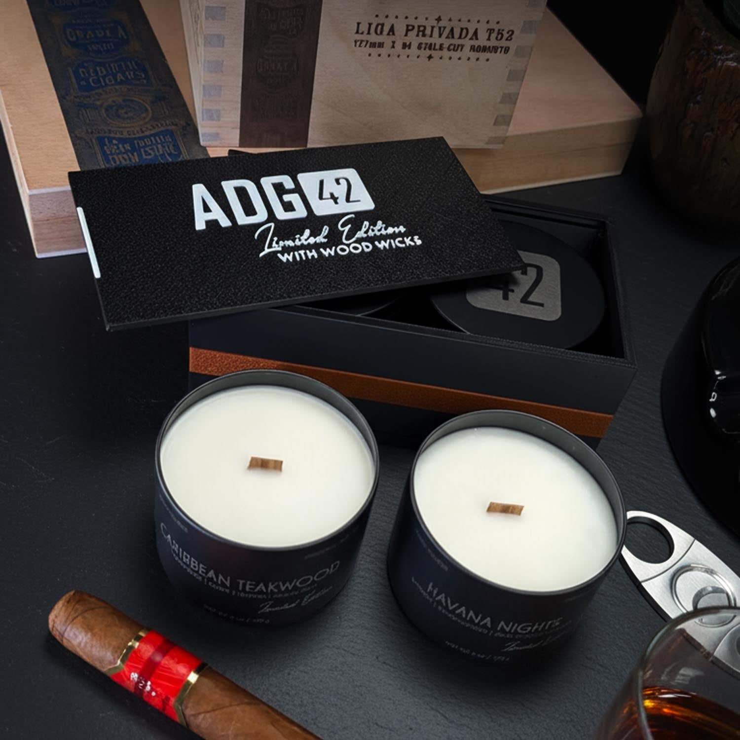 Two candles for men with wood wicks in black containers on a dark surface, with 'ADG42' branding visible.