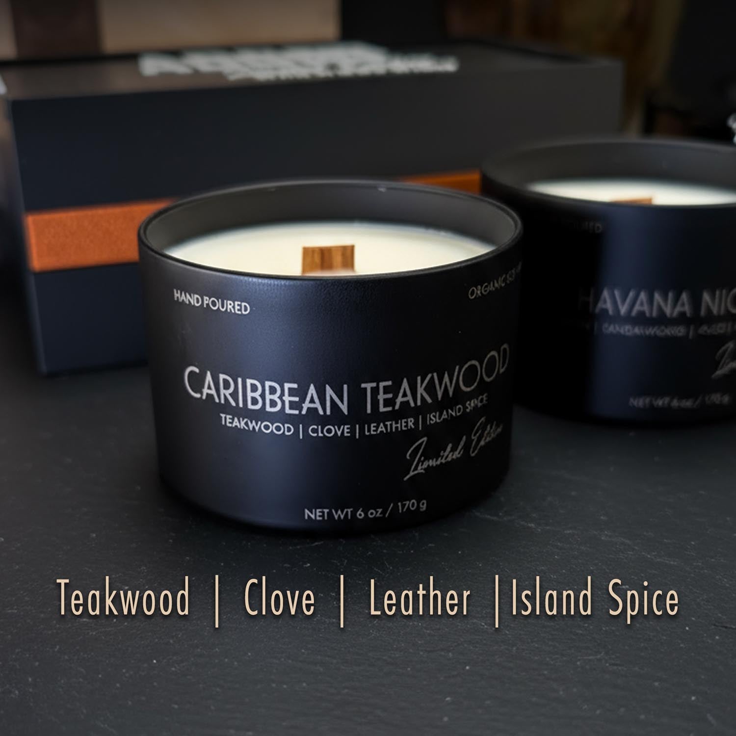 Candle for men in a black container labeled 'Caribbean Teakwood' with other candles in the background.