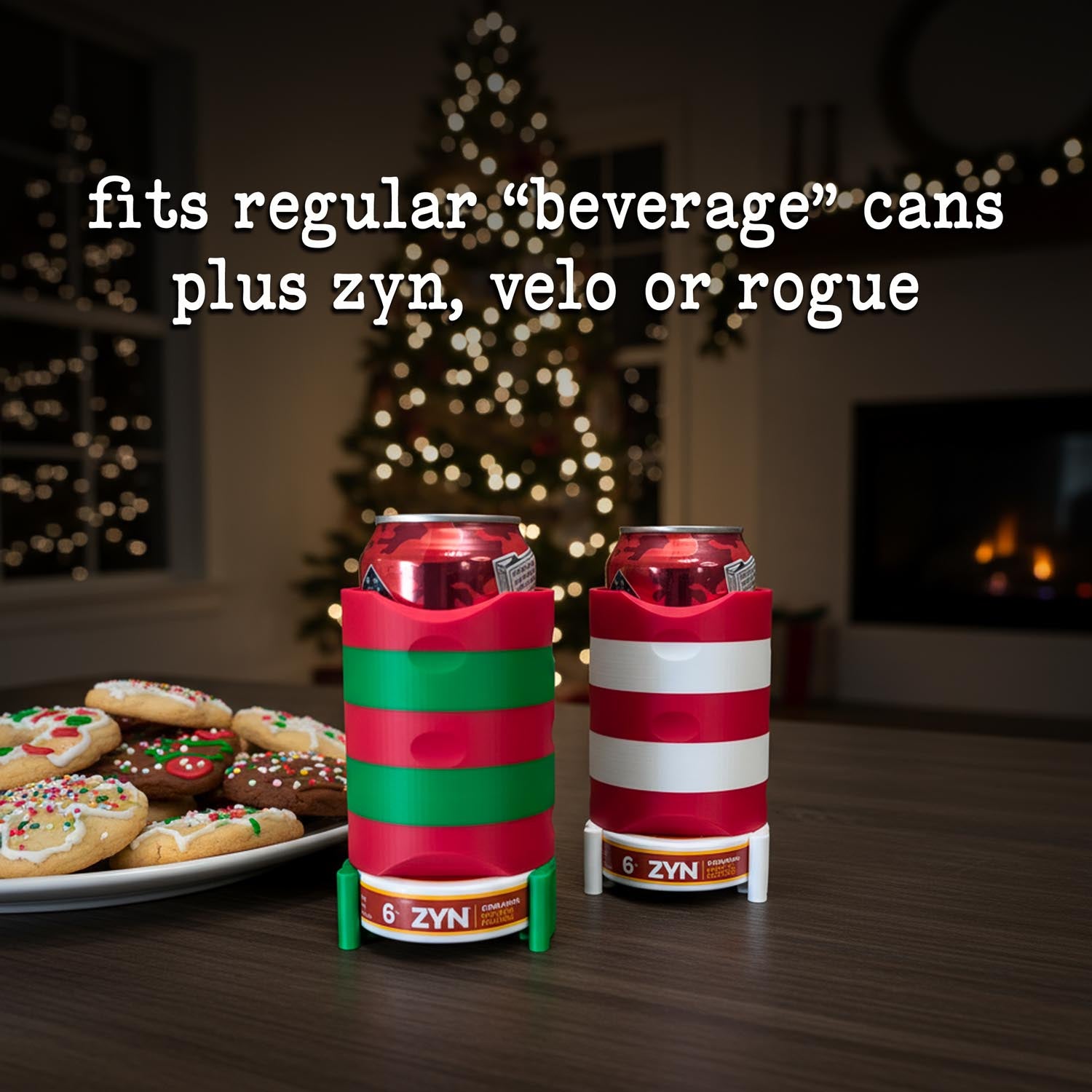 Two can coolers with Christmas design on a table with cookies and a decorated tree in the background.