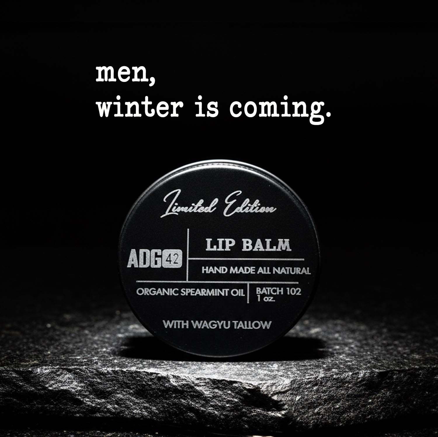 Lip balm container with text 'men, winter is coming.' on a dark background
